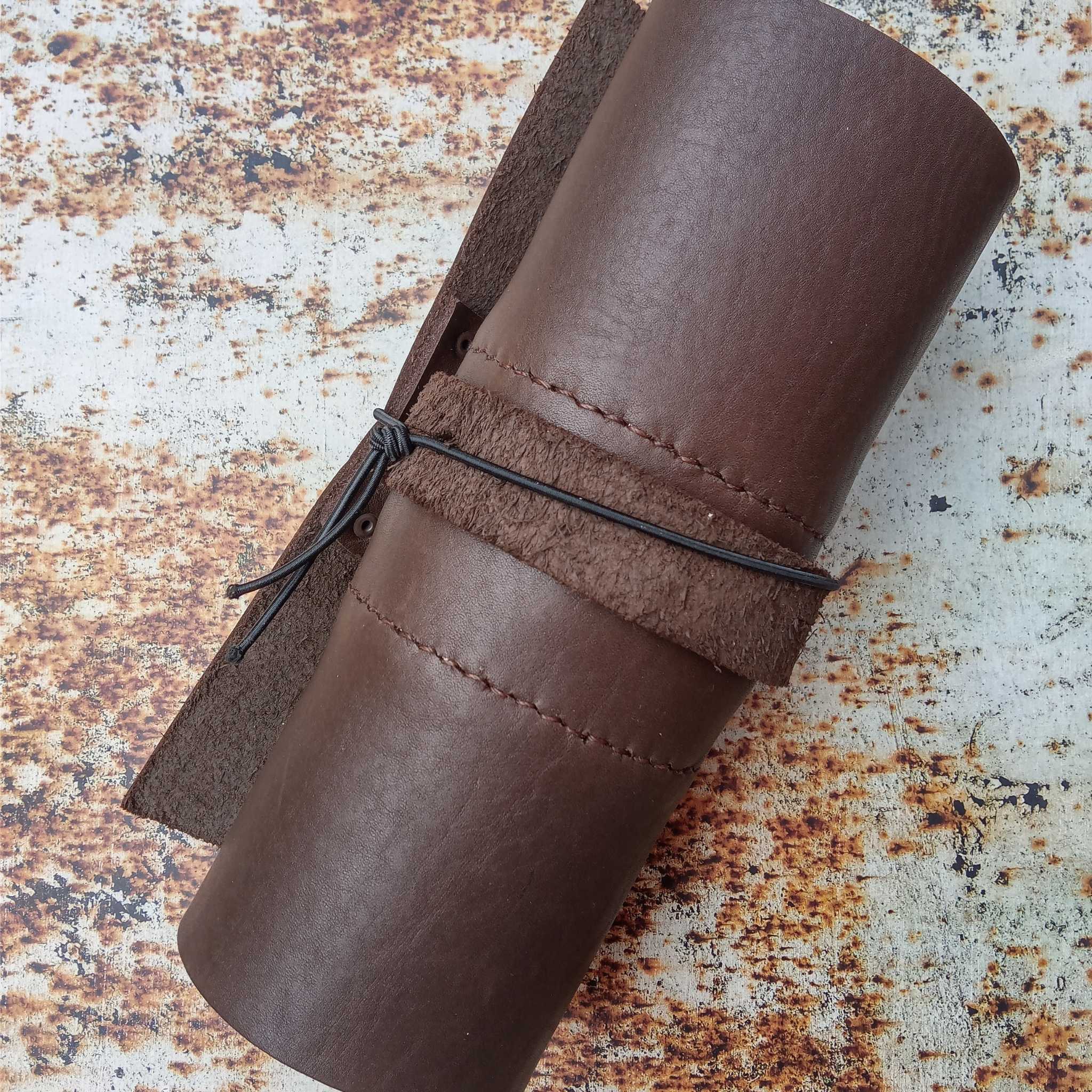 Showing a leather tool roll on an A3 printed leather rust effect backdrop