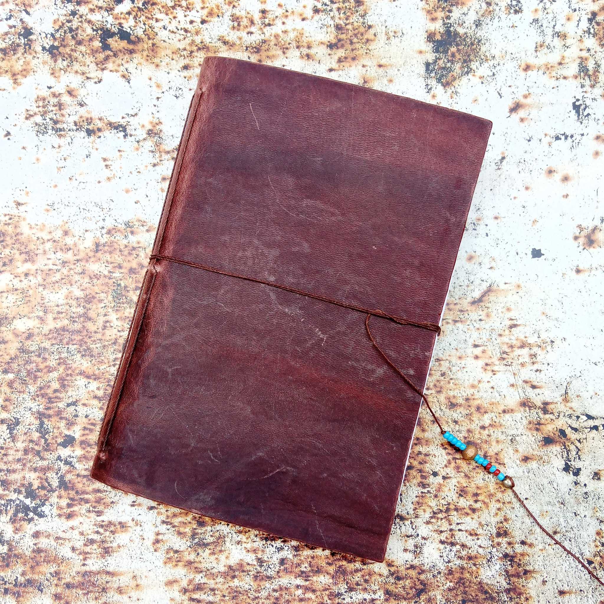 Showing a leather stitched notebook on an A3 printed rust effect photography background