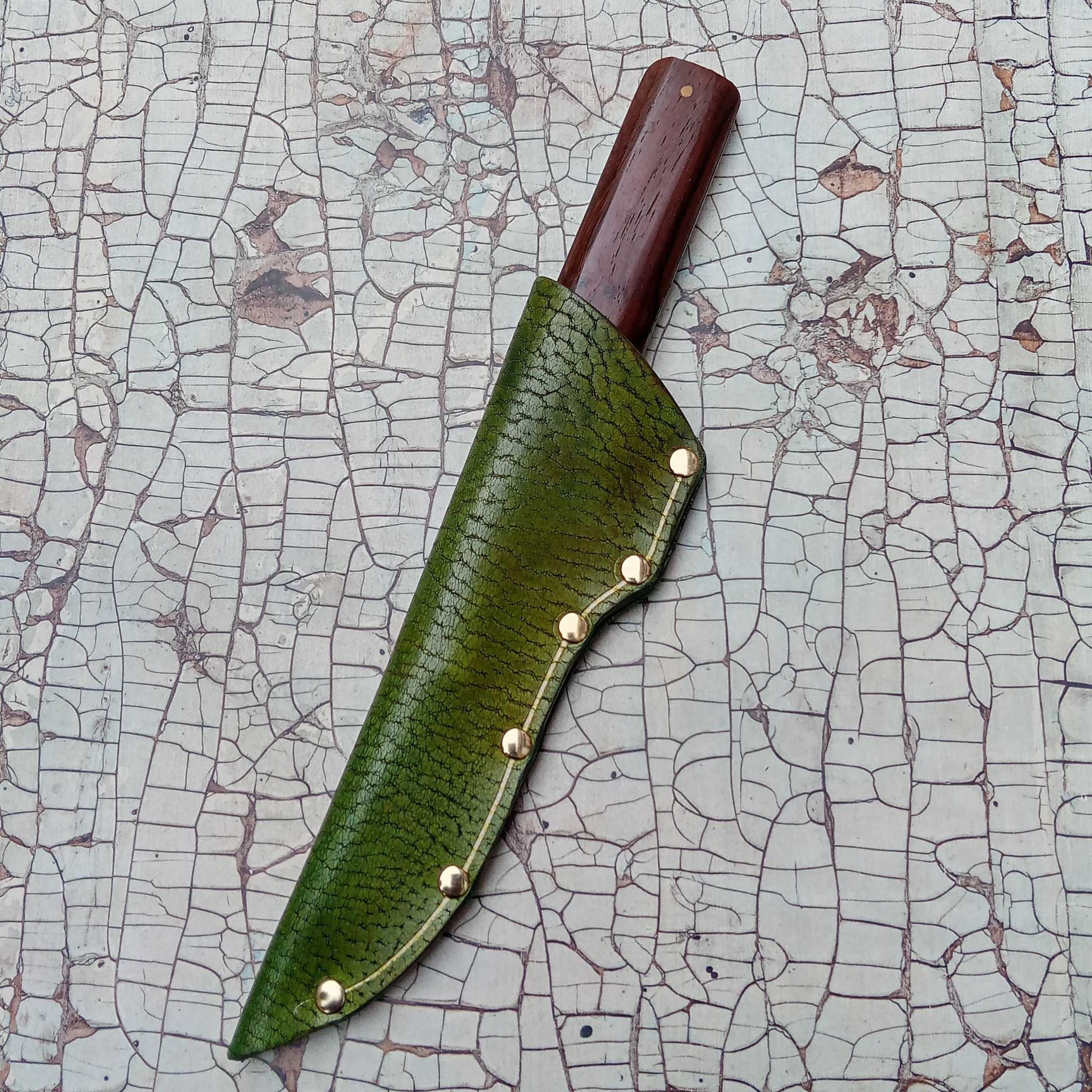 Showing a leather knife sheath on an A3 printed leather cracked effect backdrop