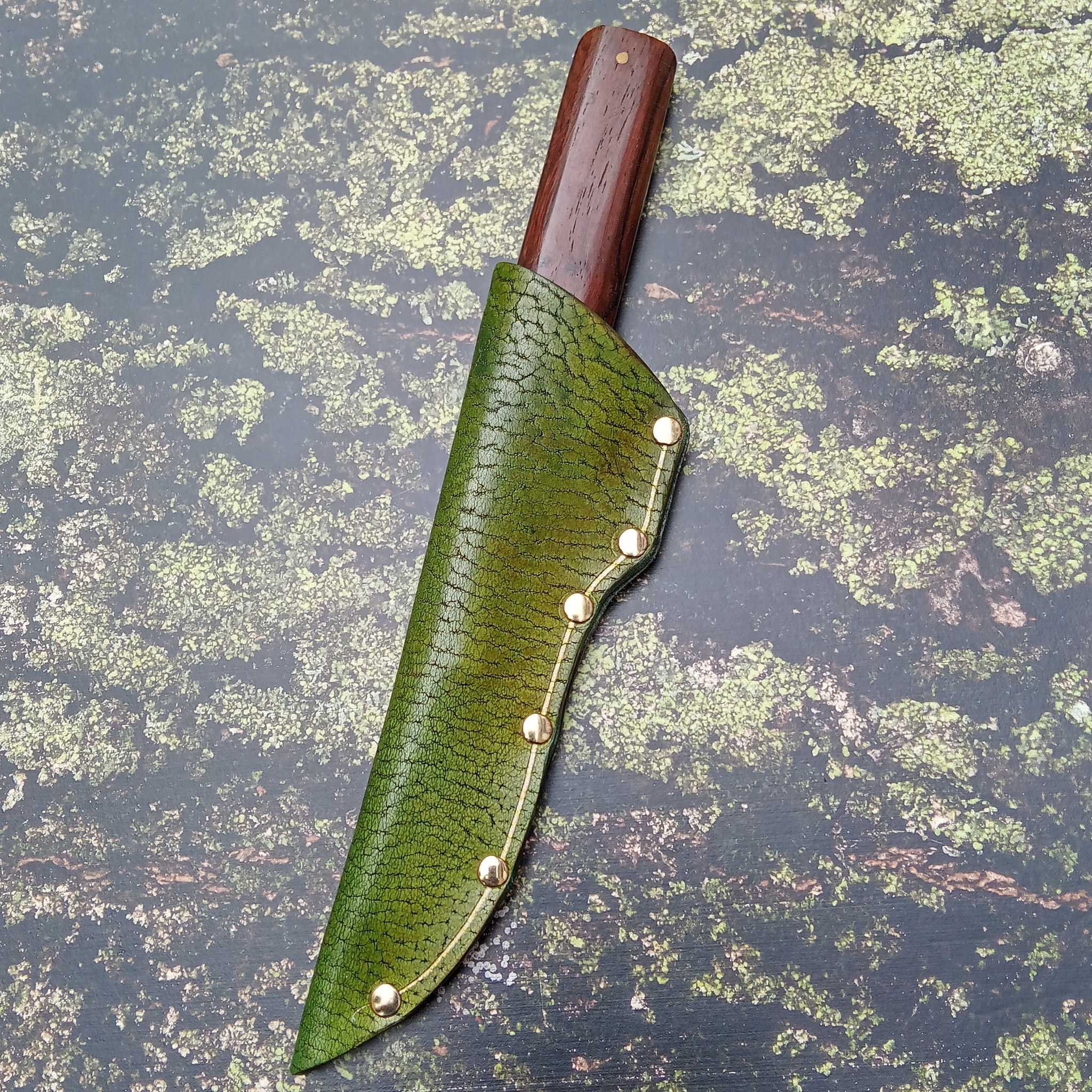 Showing a leather knife sheath on an A3 printed leather moss and bark effect backdrop