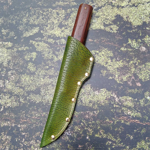 Load image into Gallery viewer, Showing a leather knife sheath on an A3 printed leather moss and bark effect backdrop
