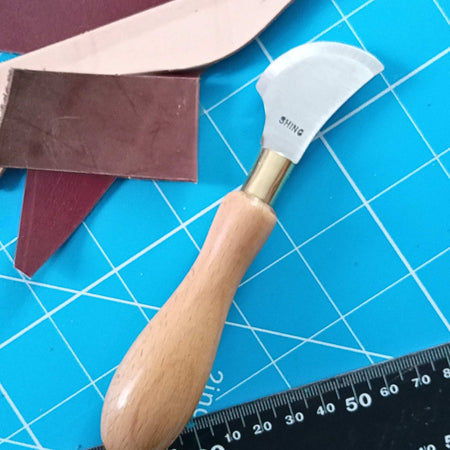 Leather cutting knife with quarter moon head, and hard wood handle, steel blade, hardened by traditional methods, with a razor ground edge. Made in the UK