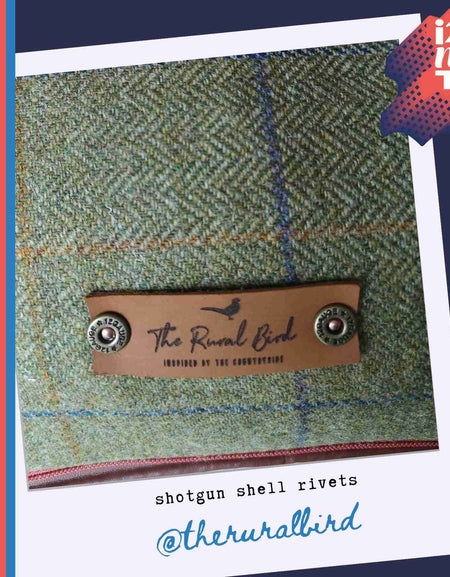 Gallery image to show a leather tag attached to tweed bag with the shotgun shell decorative rivets